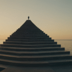 Silhouette of a figure standing at the peak of an ascending pyramid structure extending across calm waters at sunset, representing career growth and achievement through guided mentorship cyberfulness